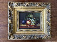 Front view of the small still life oil painting mounted in an ornate gilt frame showing the full artwork and frame details.