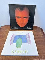 Front covers of Genesis Duke and Phil Collins No Jacket Required vinyl LPs showing artwork and artist photo.