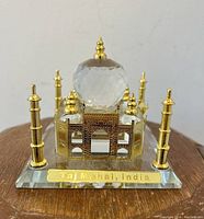 Front view of the 4-inch crystal and gold-tone metal Taj Mahal figurine with clear base and gold plaque.