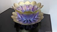 Flower-shaped lilac and gold bowl with petaled edges and gold trim on petal tips, showing deep purple shading and translucent glass.