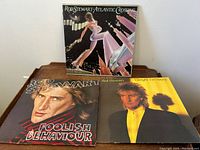Three Rod Stewart vinyl LP records shown front cover side, titles 'Atlantic Crossing', 'Foolish Behaviour', and 'Tonight I'm Yours' visible clearly.