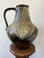 Front view of the large rounded pitcher jug with single handle showing iridescent glaze.