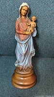 Front view of the hand-carved wooden Madonna Virgin Mary holding baby Jesus statue with delicate painted details.