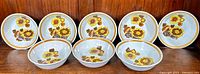 Full set of 8 Royal Doulton Lambeth stoneware 'Forest Glen' bowls arranged side-by-side showing floral pattern and shape variety.