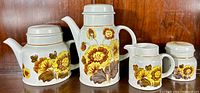 Full set of four pieces: coffee pot, teapot, cream pitcher, covered sugar bowl with yellow and brown floral 1970's pattern