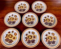 Top view showing eight Royal Doulton Lambeth stoneware side plates arranged in a circular pattern, displaying the floral Forest Glen pattern.