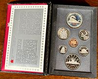 Top-down image of the 1986 Canadian Prestige Double Dollar Mint Set in original red presentation case with clear plastic coin holder containing 8 coins.