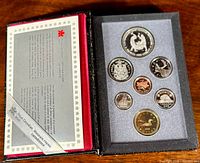 Original presentation case with certificate/specification sheet and seven coins mounted in a gray felt insert.