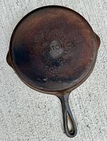 Bottom view of cast iron skillet showing embossed manufacturer's markings on base.