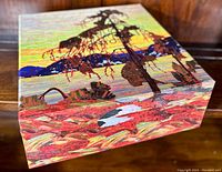 Closed original box with vibrant landscape painting artwork on lid showing trees, lake, and rock formations.