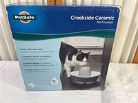 Box front showing product name, image of cat drinking from the fountain, and key features.