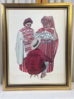 Full view of framed print showing three Guatemalan figures in traditional dress in a gold and black wood frame.