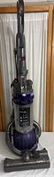 Full view of Dyson DC25 Ball upright vacuum cleaner with hose and floor brush attachment