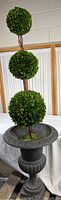 Full view of the artificial topiary plant showing three green foliage spheres on twisted stems with decorative urn base.
