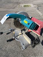 Makita 10 inch miter saw showing general view with saw blade and base.