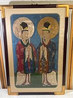 Full view of the framed folk art painting showing two male figures in traditional attire under glass with a bamboo-style frame.