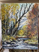 Front view of the vintage signed landscape painting showing the creek, trees, and foliage.