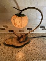 Miniature table lamp illuminated on kitchen counter, showing paper mache shade and hand carved wood base