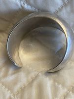 Wide silver cuff bracelet showing shape and wear.