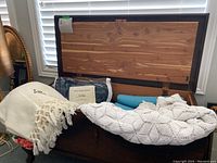 Open cedar chest filled with blankets including a white crocheted blanket and a packaged striped Trapper Blanket by L.L. Bean plus a blue wool blanket and another floral blanket.