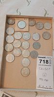 Tray displaying twenty-one Canadian fifty-cent coins including one 1957 UNC in flip