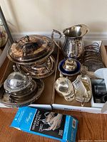 Boxed lot on floor showing covered dish on stand, pitcher, sauce boat, toast rack, two bowls with cobalt liners and gloves box