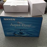 Box of Nikken PiMag Aqua Pour gravity water system in blue with branding visible
