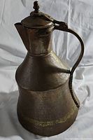 Full view of the solid copper pitcher showing overall shape, handle, spout, and body texture.