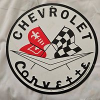 Front view of the Chevrolet Corvette round metal tin sign showing logo, lettering and condition.
