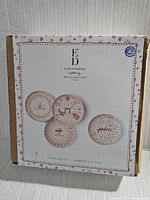 Box showing 4 plates themed with Christmas designs by Ellen Degeneres for Royal Doulton, brand name and size 8.3 inches visible