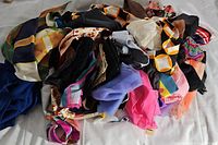 Loose pile of various vintage women's scarves showing multiple colors and patterns