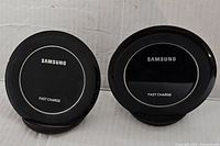 Front view of two black Samsung fast charge wireless chargers with brand and 'Fast Charge' text visible