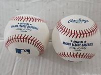 Two official Rawlings Major League Baseballs with Allen H. Selig signature and MLB logo.