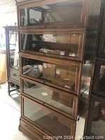 Front view of five-tier bookcase showing stacked glass-front sections