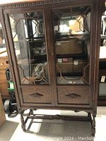Full front view of walnut china cabinet showing wood frame with glass door and lower drawer