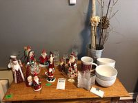 Overall table view with various Christmas figurines, bowls, and glass candle holders