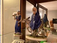 Photo of two porcelain Goebel nativity figures: Mary with baby Jesus on donkey, and Joseph with lantern