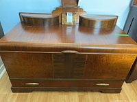 Front view of cedar chest showing decorative wood grain and lower drawer with handles.
