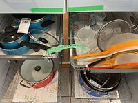 Overview of pots, pans, measuring cups, mesh strainers, and colanders in drawer