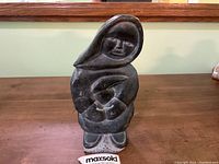 Front view of the soapstone carving showing the Inuit woman holding an infant, highlighting the detailed hood and facial features.