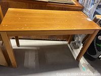 Photo of small oak table showing general wear and water damage on the surface, rectangular shape with four legs.