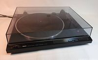 Front angle view of Yamaha TT-300U turntable with dust cover closed, showing front controls and logo.