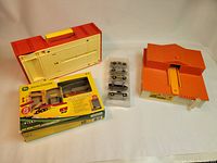 Overview of all items in the lot: carrying case, playsets, boxed set and toy cars.