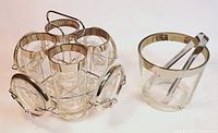 11 pieces including 4 silver band highball glasses in metal drink caddy, 4 silver band coasters attached to caddy, glass ice bucket with silver band, and metal ice tongs.
