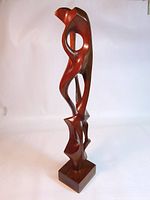 Front view of the midcentury teak biomorphic sculpture showing smooth flowing abstract shapes with cutouts mounted on square base.