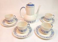 Photo of the full coffee set showing carafe, four cups, and four saucers, all decorated in blue Cranbourne floral pattern on white pottery.