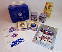 Photo showing entire lot including the blue Loblaws lunchbox with autographs, boxed commemorative baseballs, tins, booklet, and scorebook.