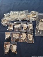 All 16 rings individually bagged with retail tags, displayed on blue fabric background