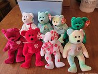 Full view of the 8 Beanie Babies plush bears in various colors and designs arranged on a flat surface.