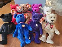 Photo showing all 8 different colored Beanie Baby bears together on a table with tags visible